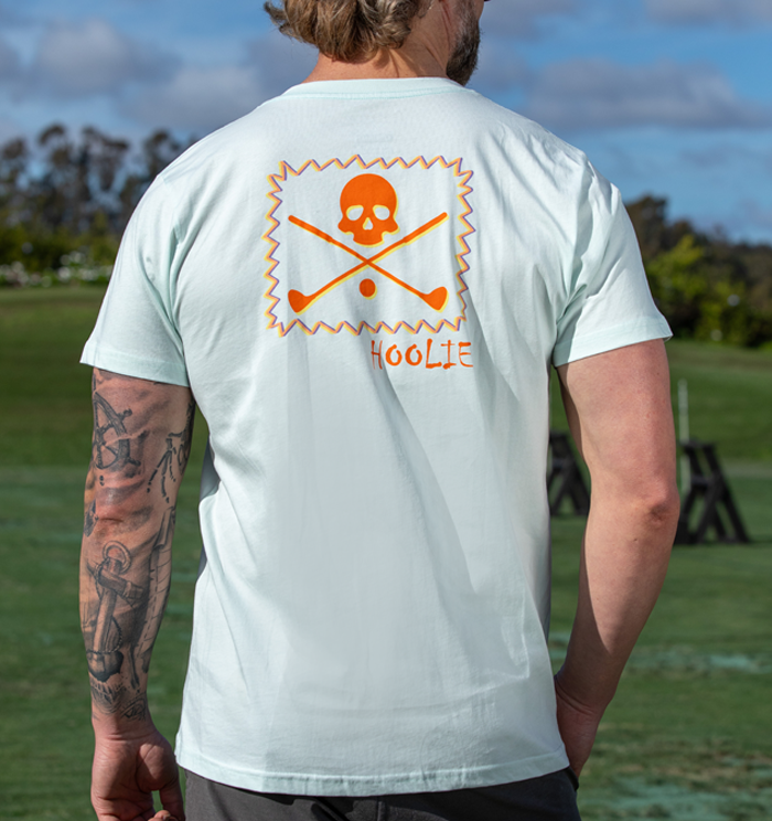 Golf T Shirt for Men in Iceberg with orange and yellow vintage X Bones graphic and multicolor zig-zag box.