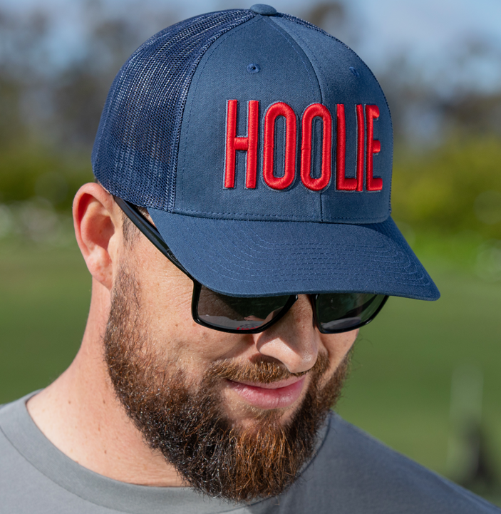 Men's Blue-Red Hoolie Bold Golf Trucker Hat with blue 3D HOOLIE logo embroidery, rope accent, and mesh back.