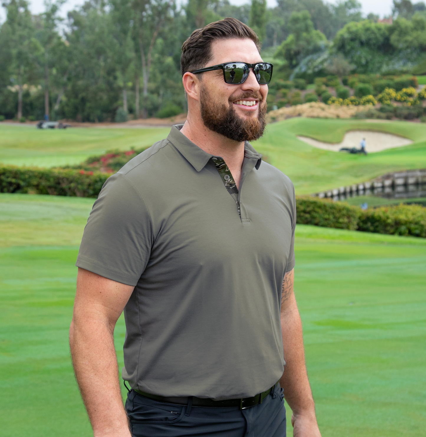 Man wearing sunglasses and the Olive Classic Men's golf polo on a golf course