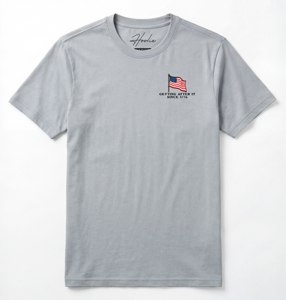 Front of Light gray T-shirt with American Flag that says Getting After it Since 1776