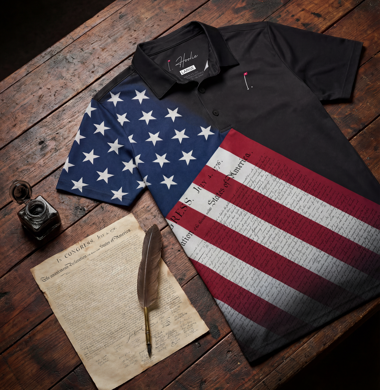 Patriotic Men's Black Golf Polo shirt on a Wooden Table with an old parchment and Revolutionary era writing quill. Polo has an American flag design with Declaration of Independence overlay - Inspired by USA's 250th