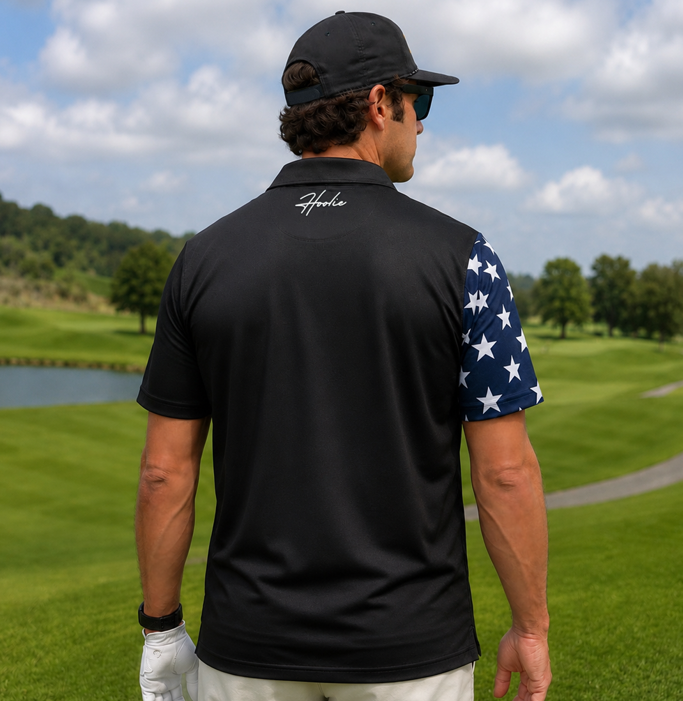 Man on golf course facing away wearing a patriotic Men's Black Golf Polo shirt with American flag design with Declaration of Independence overlay on the polo.