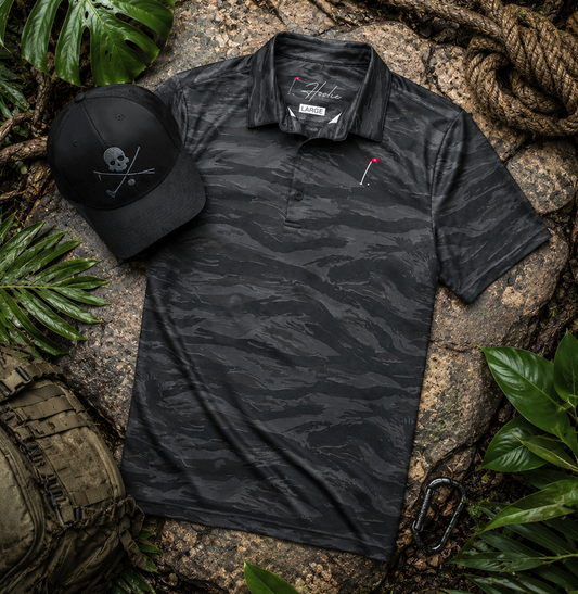 Black Tiger Stripe Polo and Black X Bones II Hat laying on jungle floor as part of the Operator's Bundle